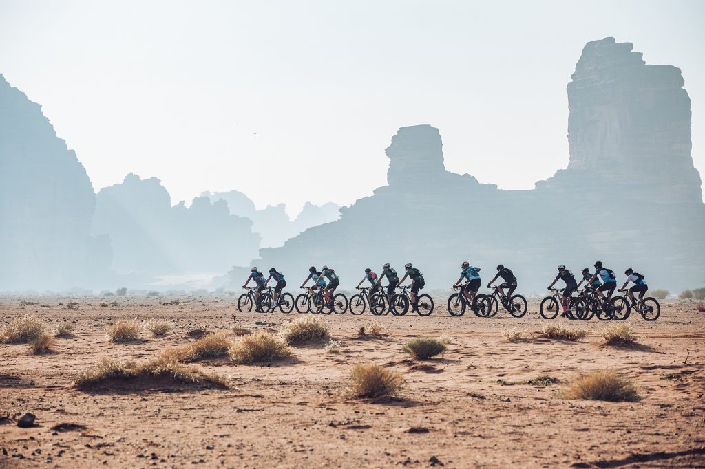 gente montando en bicicleta por el desierto