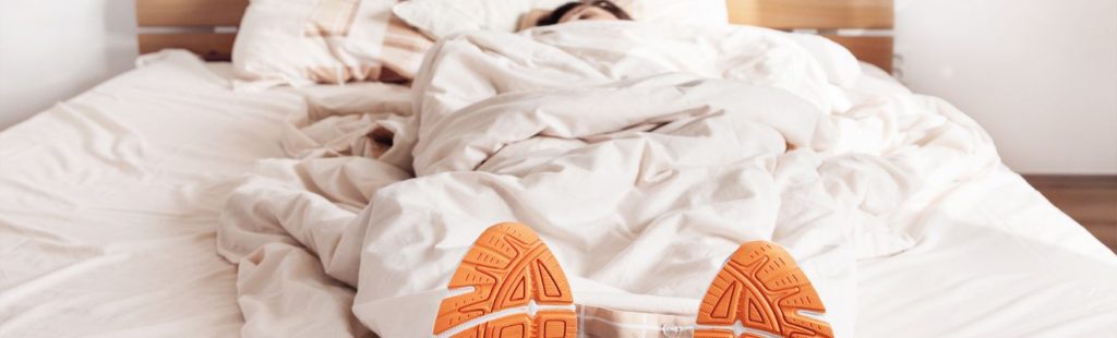 mujer con deportivas durmiendo en la cama