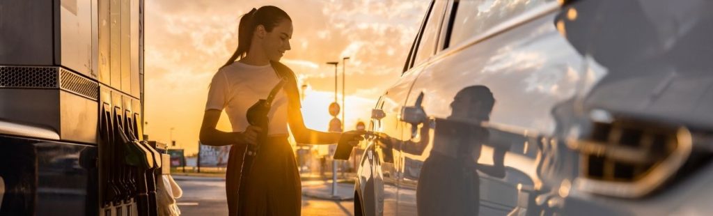 chica en un surtidor de gasolina