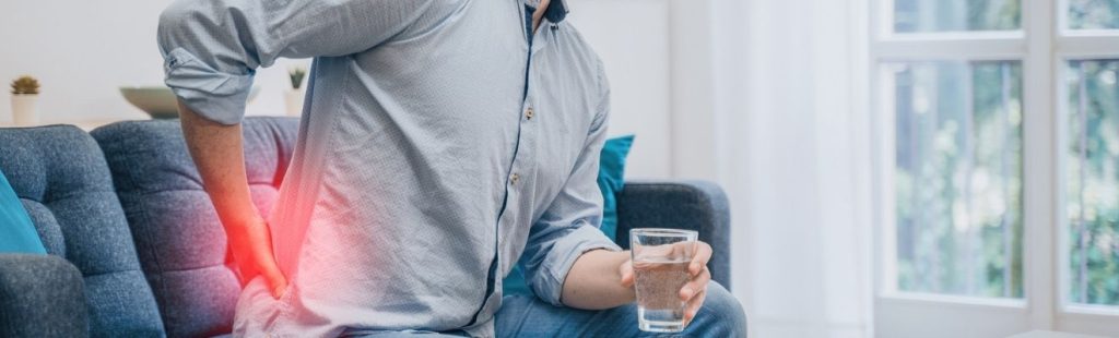persona con dolor lumbar sentada en un sofá