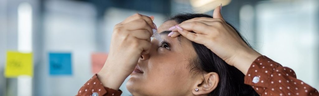 mujer echándose gotas en los ojos