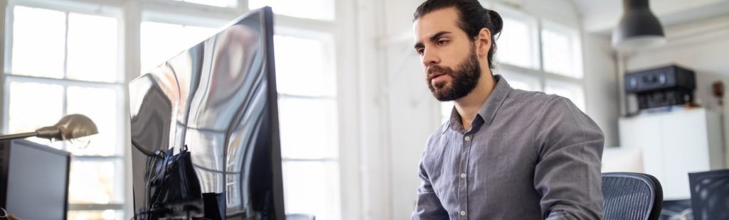 empleado oficina sentado delante de un monitor