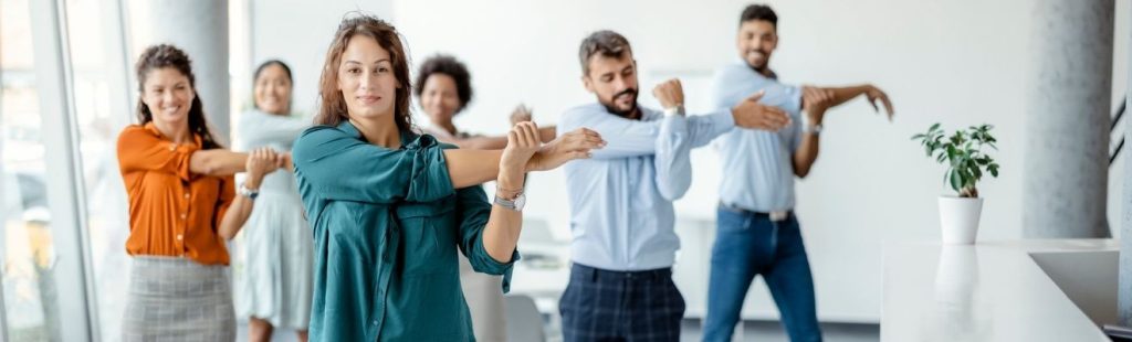 empleados haciendo ejercicios de estiramiento en la oficina