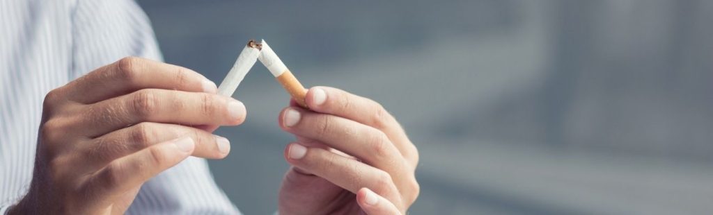 persona cortando un cigarrillo por la mitad
